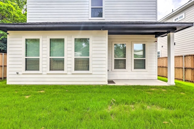 back of house with a lawn and a patio