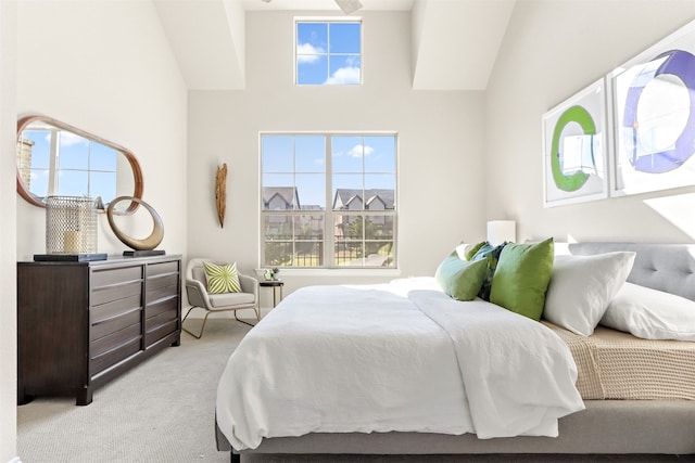 carpeted bedroom with high vaulted ceiling and multiple windows