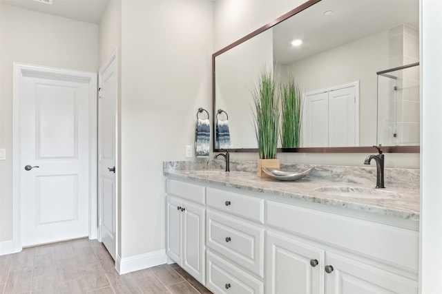 bathroom with walk in shower, wood-type flooring, and vanity