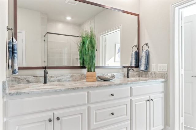 bathroom featuring walk in shower and vanity