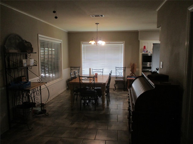 dining room with a chandelier and ornamental molding