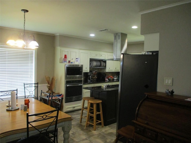 kitchen with decorative light fixtures, a kitchen breakfast bar, stainless steel appliances, white cabinets, and island range hood