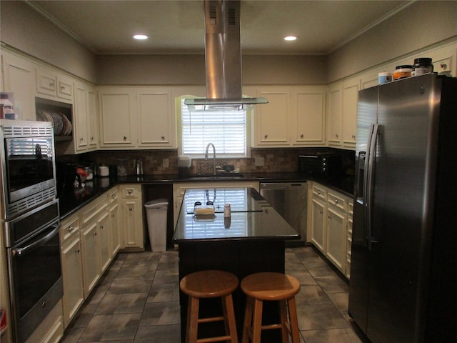 kitchen featuring appliances with stainless steel finishes, dark tile patterned floors, a kitchen island, sink, and island range hood