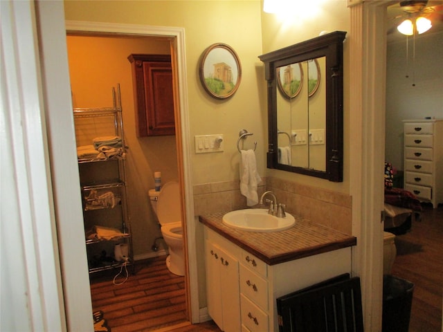 bathroom featuring hardwood / wood-style flooring, toilet, and vanity