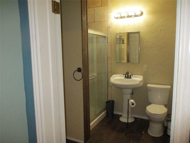 bathroom featuring toilet, wood-type flooring, an enclosed shower, and sink