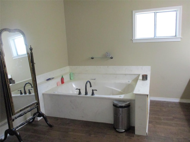 bathroom with wood-type flooring and a washtub