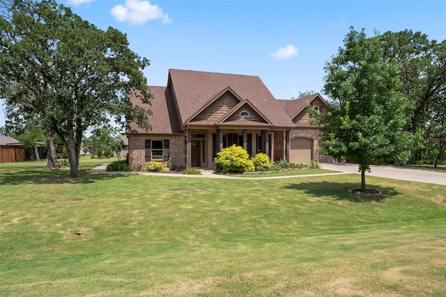 craftsman-style house featuring brick siding, an attached garage, driveway, and a front lawn