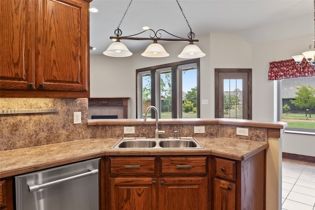 kitchen featuring sink, decorative light fixtures, dishwasher, and light tile patterned floors