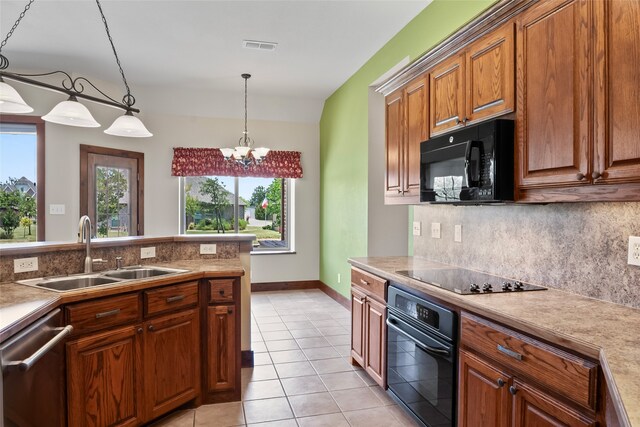 kitchen featuring hanging light fixtures, light tile patterned floors, black appliances, and decorative backsplash