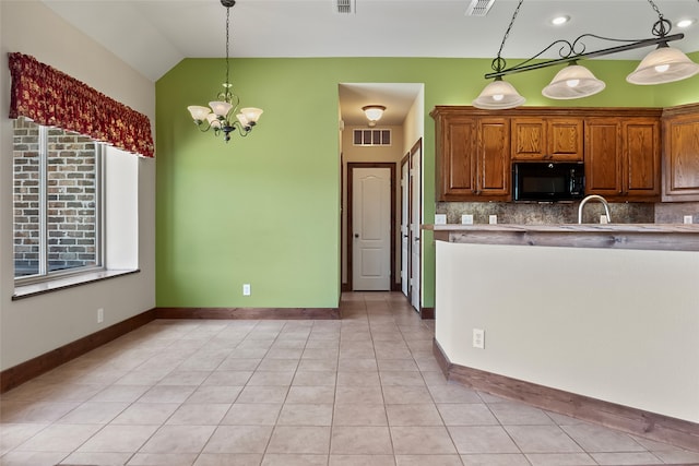 kitchen with decorative backsplash, hanging light fixtures, light tile patterned floors, and an inviting chandelier