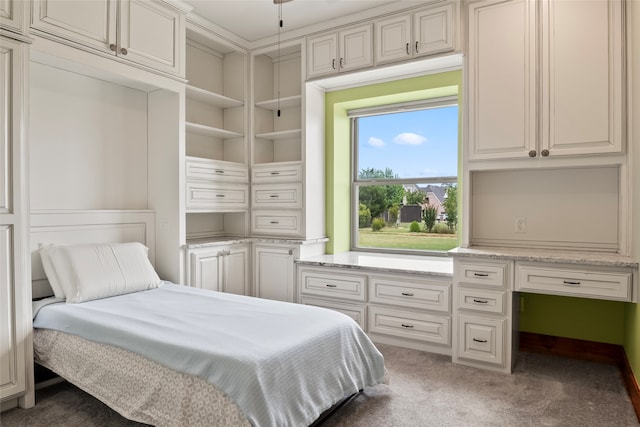 bedroom featuring built in desk and carpet