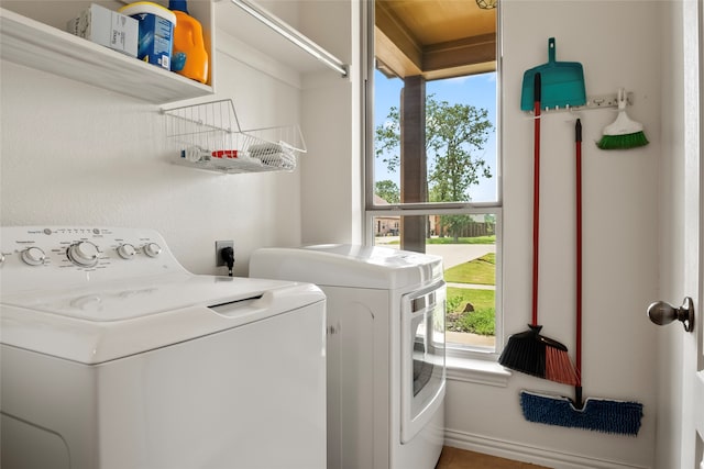 clothes washing area with plenty of natural light and washer and clothes dryer