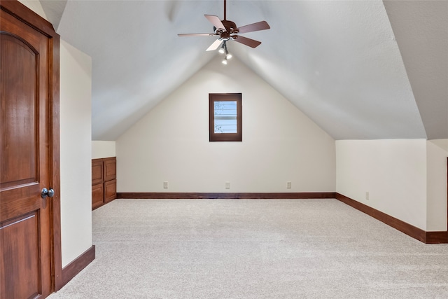 bonus room with ceiling fan, vaulted ceiling, and light colored carpet