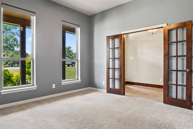 carpeted spare room with french doors