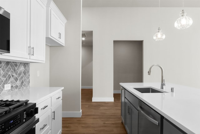 kitchen featuring tasteful backsplash, appliances with stainless steel finishes, sink, decorative light fixtures, and white cabinets