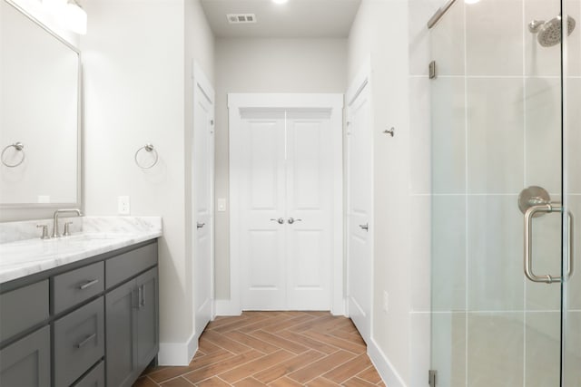 bathroom featuring vanity, parquet floors, and walk in shower