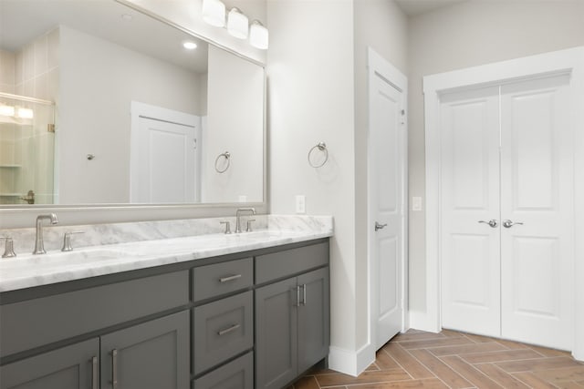 bathroom featuring parquet flooring, vanity, and a shower with shower door