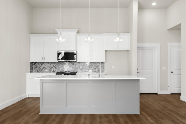 kitchen with a center island with sink, stainless steel appliances, and dark hardwood / wood-style floors