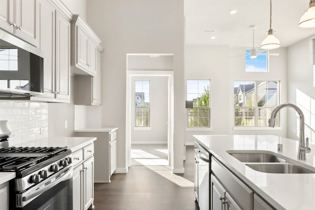 kitchen with a sink, dark wood finished floors, appliances with stainless steel finishes, and light countertops