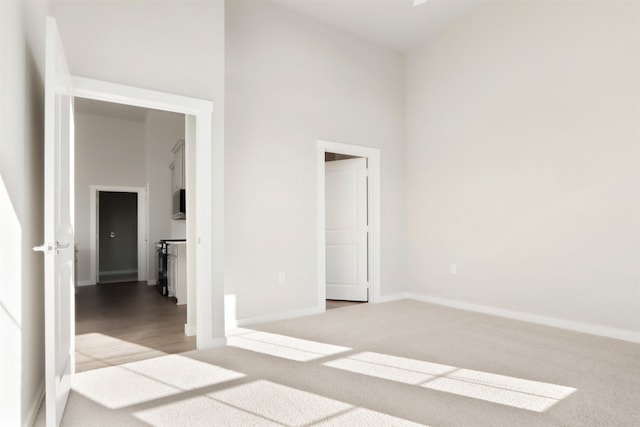 spare room with a high ceiling and carpet floors