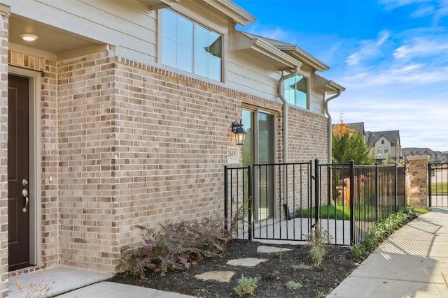 view of home's exterior with brick siding and fence