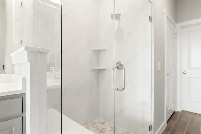 bathroom with vanity, a stall shower, and wood finished floors