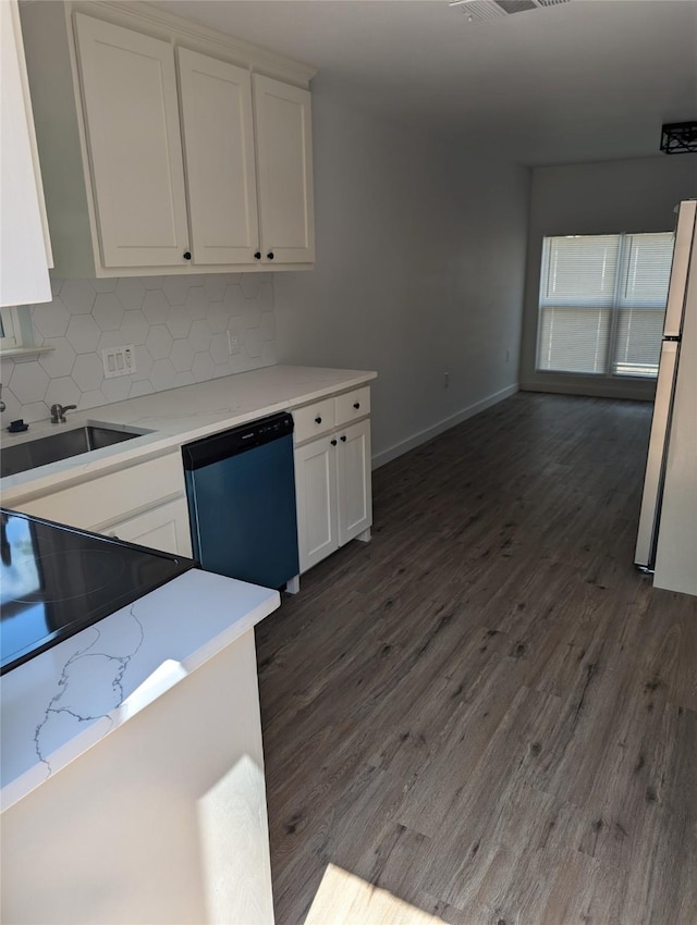 kitchen featuring decorative backsplash, dark hardwood / wood-style flooring, stainless steel dishwasher, white fridge, and white cabinetry