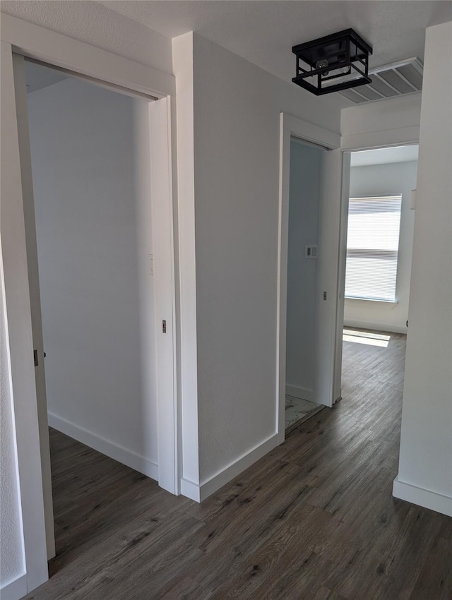 hallway with dark hardwood / wood-style flooring