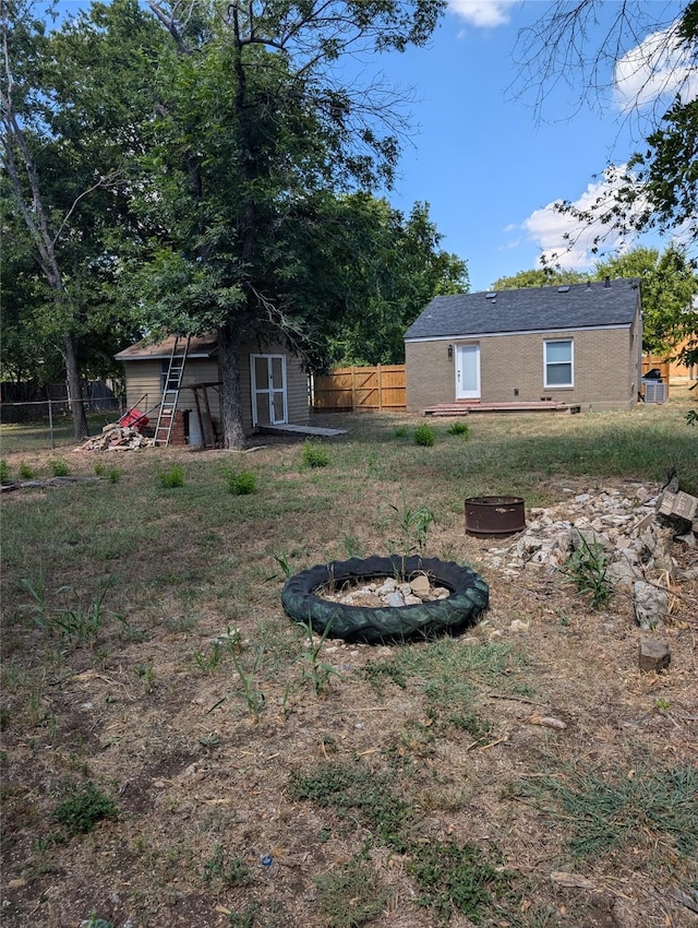 view of yard with a fire pit and a storage shed