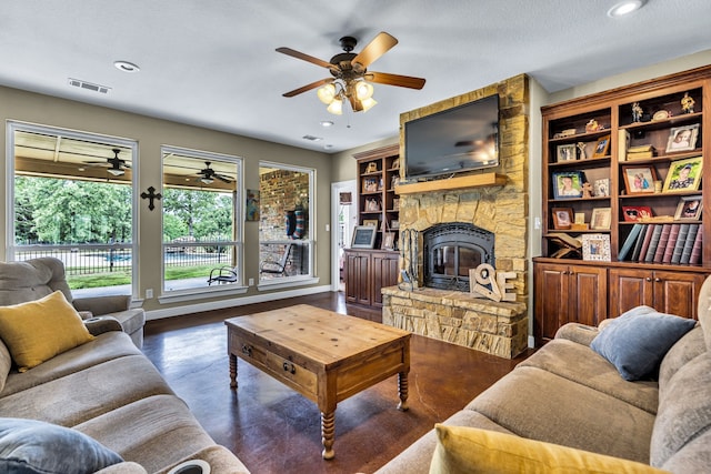 living room featuring ceiling fan, a fireplace, dark hardwood / wood-style floors, and a textured ceiling