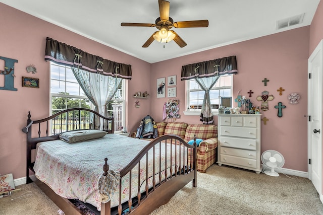 carpeted bedroom featuring multiple windows and ceiling fan