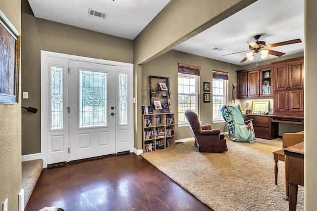 entryway with ceiling fan, dark hardwood / wood-style floors, and built in desk