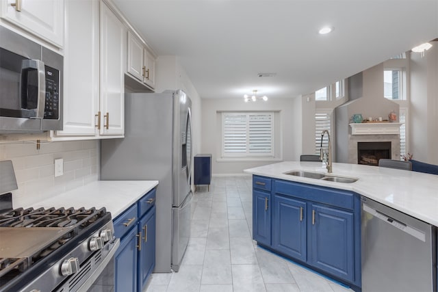 kitchen with white cabinets, sink, appliances with stainless steel finishes, and blue cabinetry