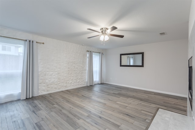 unfurnished room with ceiling fan and light wood-type flooring