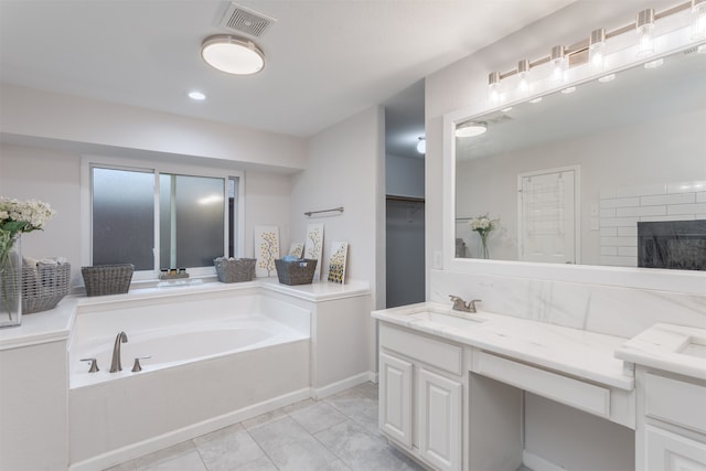 bathroom with vanity, tile patterned flooring, and a bathtub