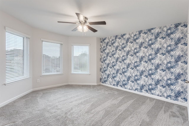 carpeted empty room featuring a wealth of natural light and ceiling fan