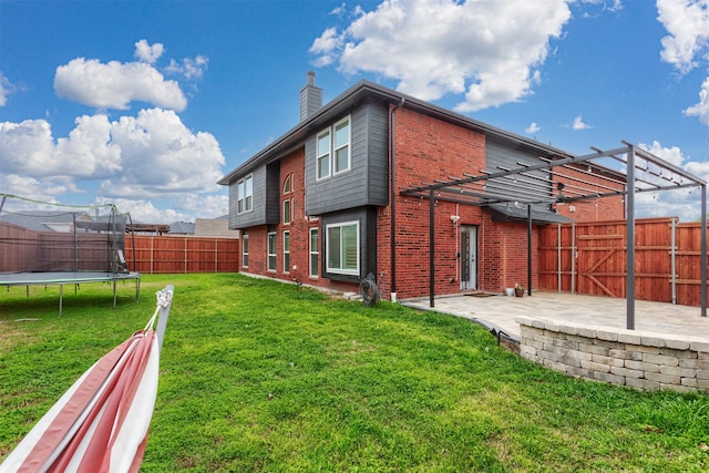 view of side of home with a pergola, a trampoline, a patio, and a lawn