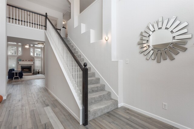 stairs featuring a high ceiling and wood-type flooring