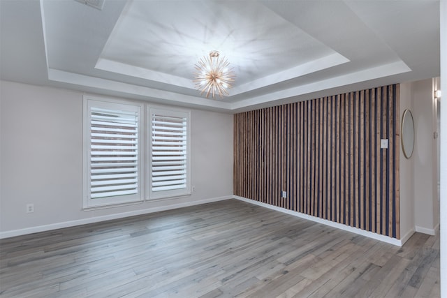 empty room featuring hardwood / wood-style floors and a tray ceiling