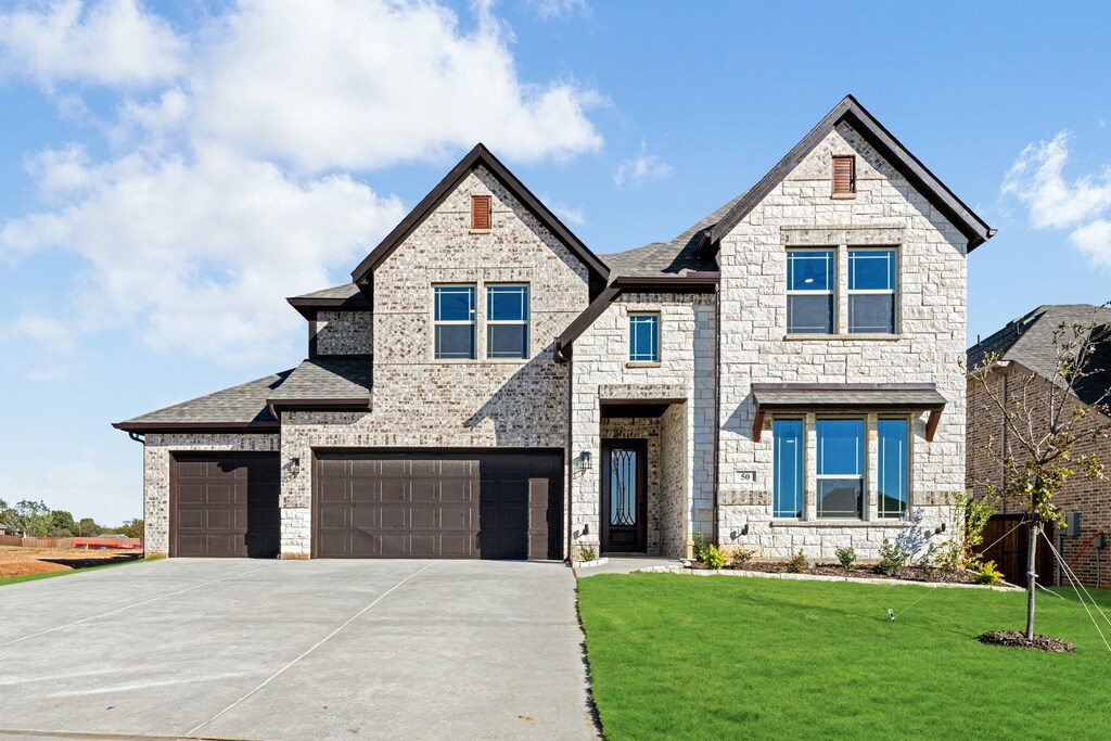 view of front of home with a front yard and a garage