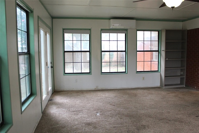 carpeted empty room featuring built in features and a wall mounted air conditioner