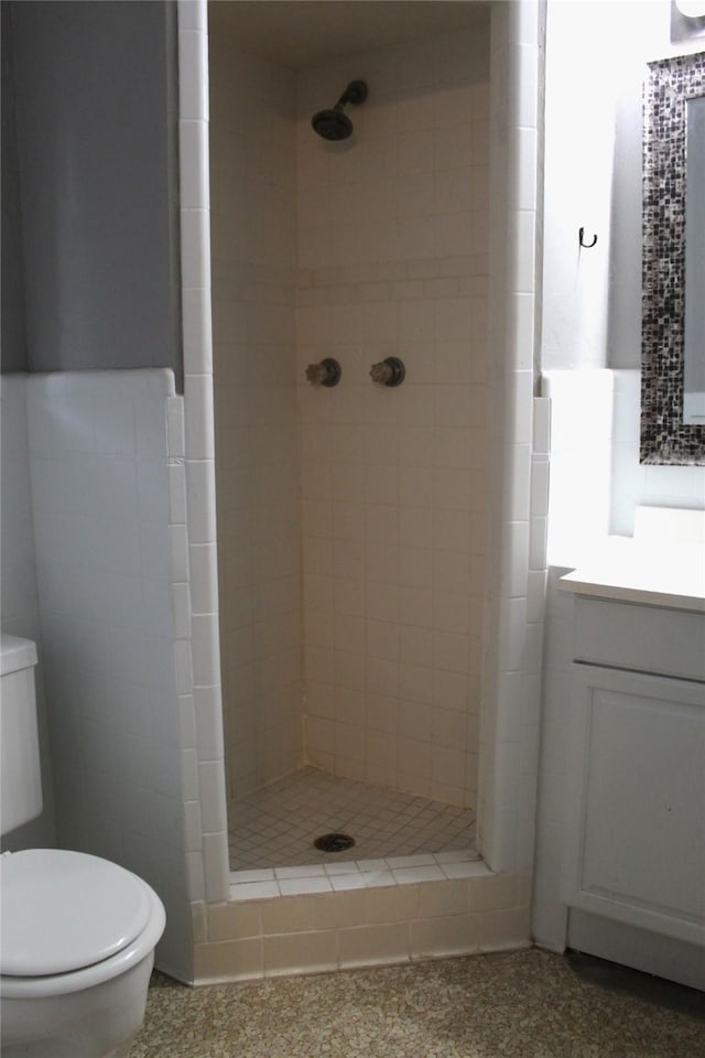 bathroom featuring tiled shower, vanity, and toilet