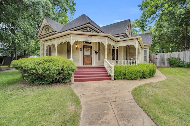 victorian-style house featuring a front lawn and a porch