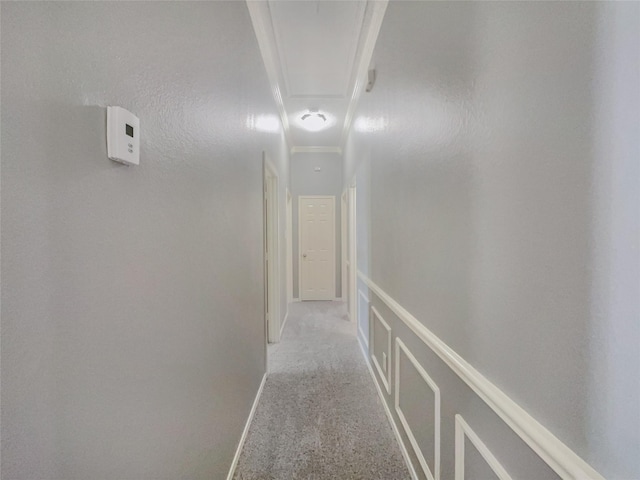 hallway featuring crown molding and light carpet