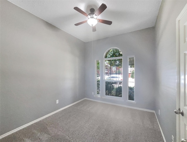 carpeted spare room with ceiling fan