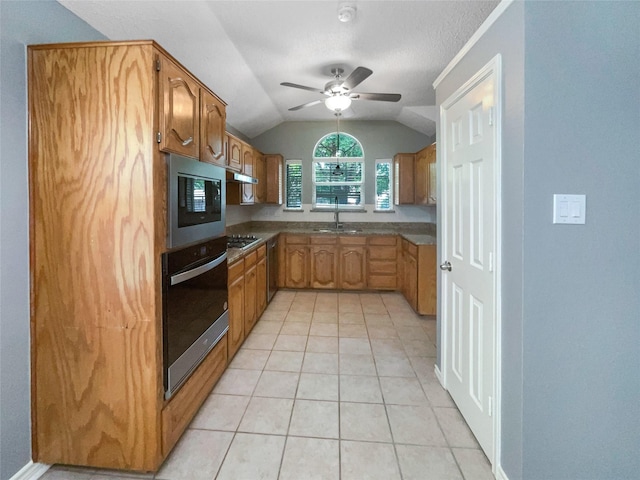 kitchen featuring lofted ceiling, sink, ceiling fan, light tile patterned floors, and stainless steel appliances