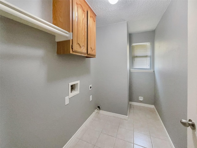 clothes washing area featuring cabinets, washer hookup, light tile patterned floors, a textured ceiling, and hookup for an electric dryer