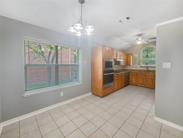 kitchen with ceiling fan with notable chandelier, stainless steel appliances, vaulted ceiling, sink, and pendant lighting