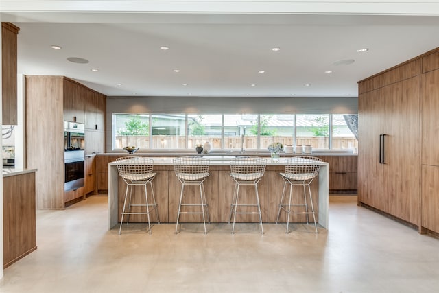 kitchen with a breakfast bar, a kitchen island, and double oven