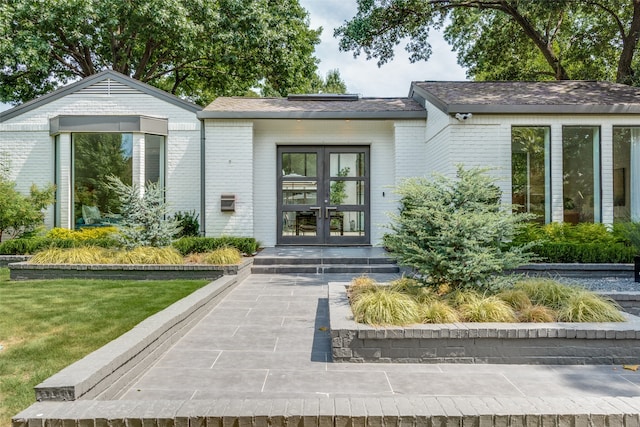 entrance to property featuring french doors and a yard